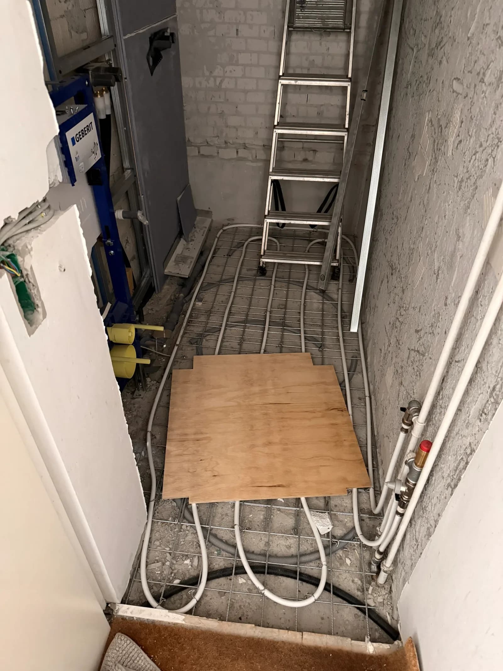 Gulvvarmeslanger bundet til armeringsnet i badegulvet, klar til afretning.