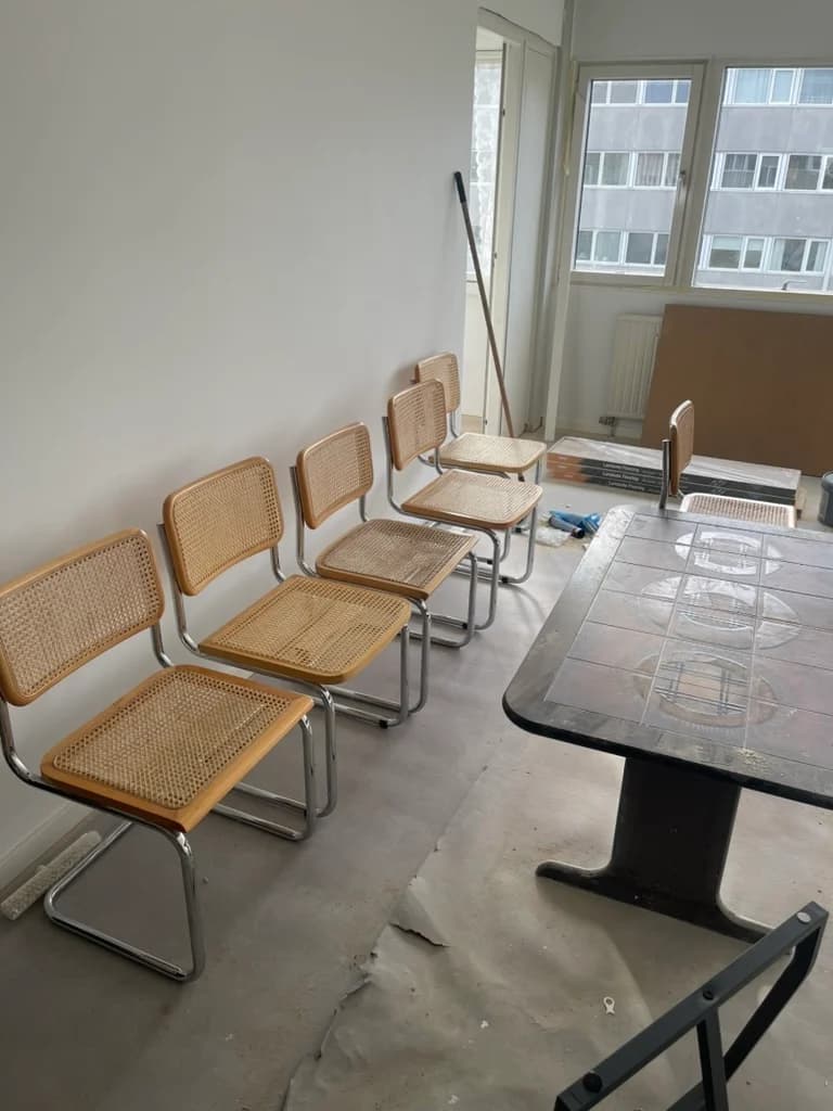 Stuen før gulvet blev lagt: bart undergulv og møblerne stillet sammen langs væggen.