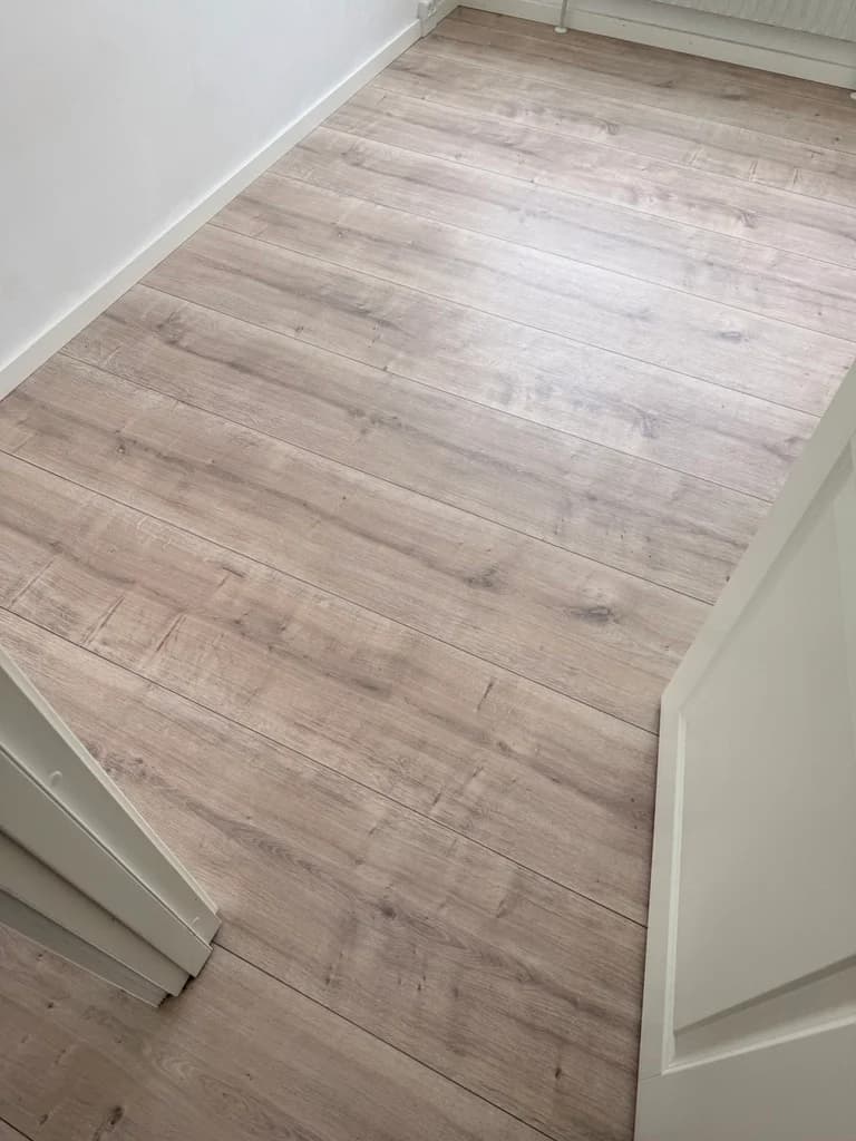Plankegulv ført ubrudt gennem døråbningen — Dommervænget, Roskilde