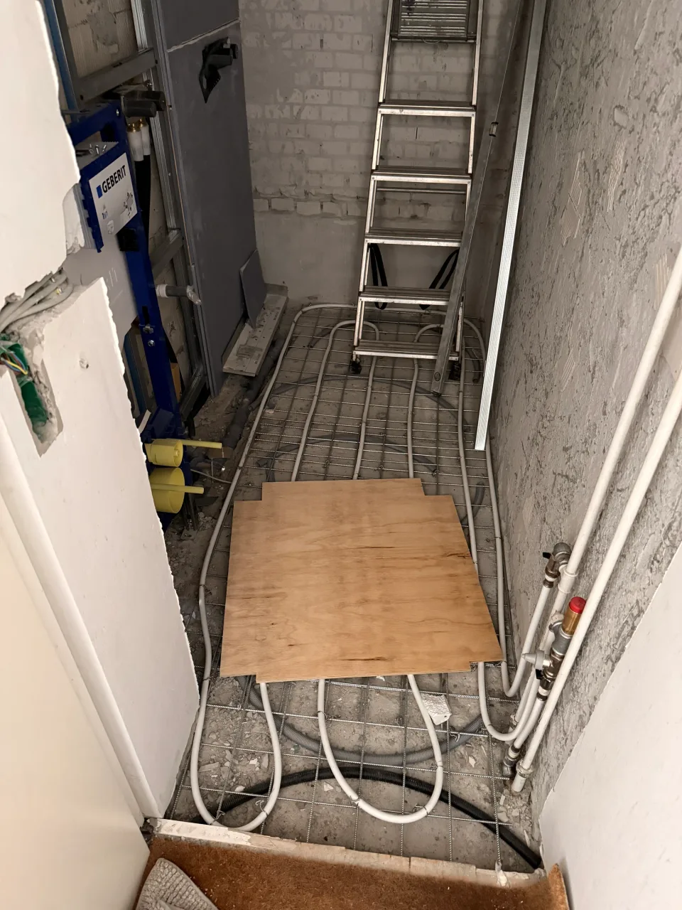 Gulvvarmeslanger bundet til armeringsnet i badegulvet, klar til afretning.